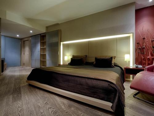 a bedroom with a large bed and a pink couch at Sofitel Barcelona Skipper in Barcelona
