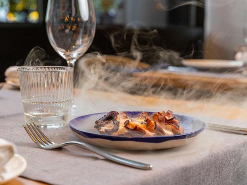 a plate of food on a table with a glass at Sofitel Barcelona Skipper in Barcelona