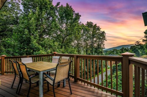 Una terraza de madera con una mesa y sillas. en Distiller'S Den Cabin Cabin, en Gatlinburg