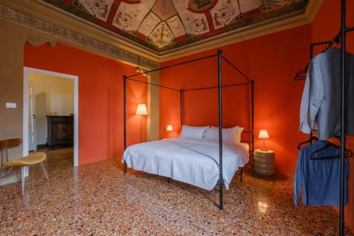 una camera da letto con un letto con una parete arancione di Unique Bologna Penthouse with Frescoes and Charm a Bologna