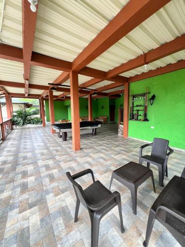a large room with ping pong tables and chairs at KETHALYA TAYRONA Hostal in El Zaino