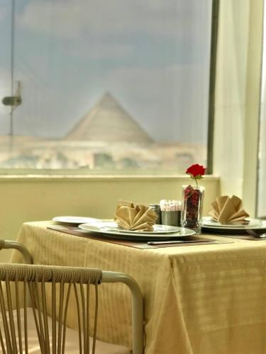 a table with plates and napkins on top of it at Pyramids INN View in Cairo