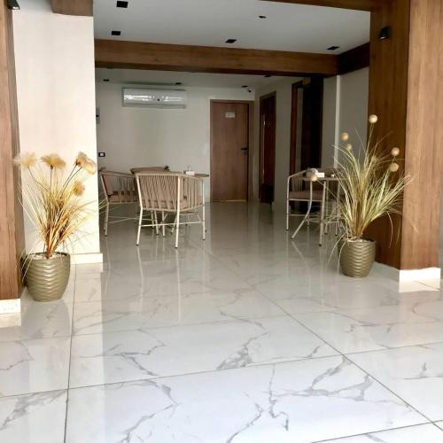 a lobby with white marble floors and chairs and plants at Pyramids INN View in Cairo