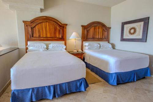 two beds in a hotel room with two beds at Barceló Karmina - All Inclusive in Manzanillo