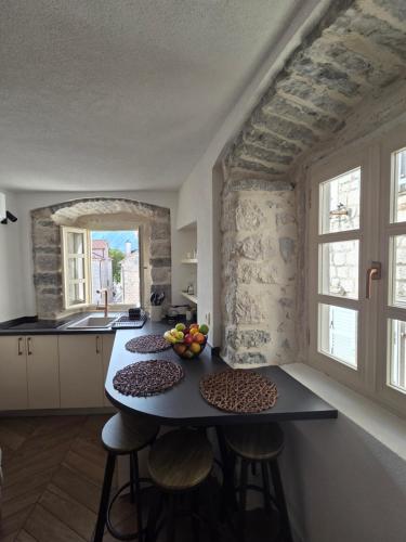 a kitchen with a table with fruits on it at Bel Composto Apartments in Perast