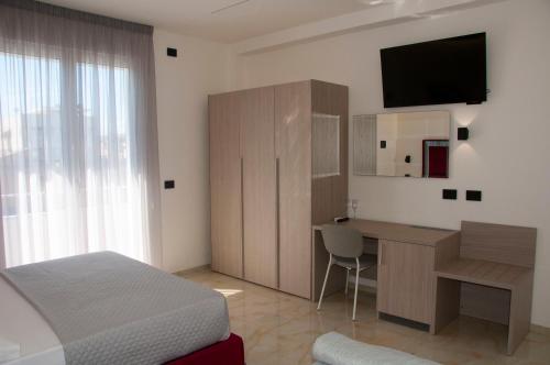 a bedroom with a bed and a desk and a television at D'ANNUNZIO suites in Martinsicuro