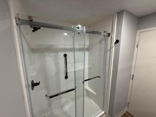a shower with a glass door in a bathroom at Ramada by Wyndham Albuquerque Midtown in Albuquerque