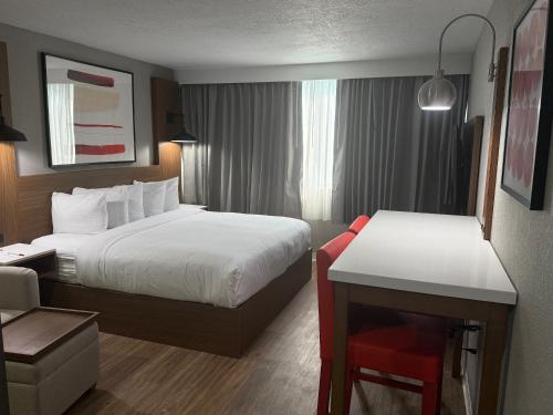 a hotel room with two beds and a desk at Ramada by Wyndham Albuquerque Midtown in Albuquerque