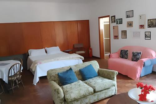 una sala de estar con un sofá y una cama en Pousada Sítio São Luiz - Café da Manhã Piscina - Petrópolis, en Petrópolis