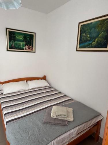 two beds in a room with two pictures on the wall at Nemira IX Vacations in Omiš