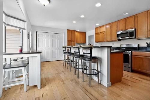 Una cocina con gabinetes de madera y taburetes de bar. en Grass Lake Retreat with Game Room & Fire Pit, en Grass Lake