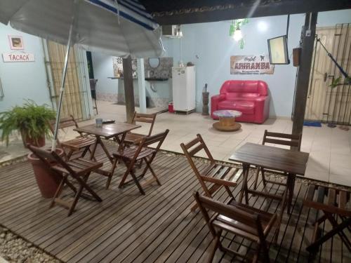 a patio with tables and chairs and a red couch at Hostel Ariramba in Belém