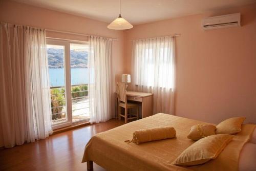 Un dormitorio con una cama y un escritorio y una ventana. en Apartments Star 3, en Pag