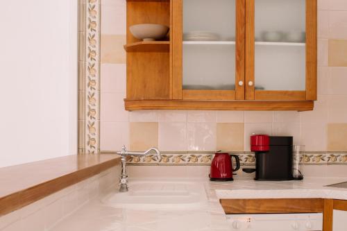 a kitchen with a sink and a red appliance at Antic Rooms Filador in Villajoyosa