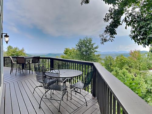 a table and chairs on a deck with a view at Kickback Kabin in Gatlinburg