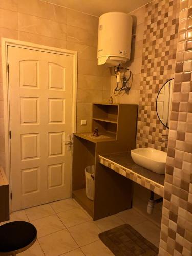 a bathroom with a sink and a white door at Iravola Hebergement in Antananarivo