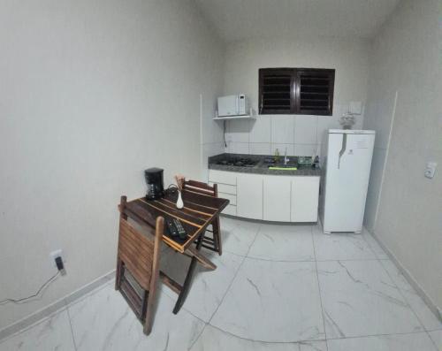 a kitchen with a refrigerator and a table in it at Residencial Rosa da Barra in Canguaretama
