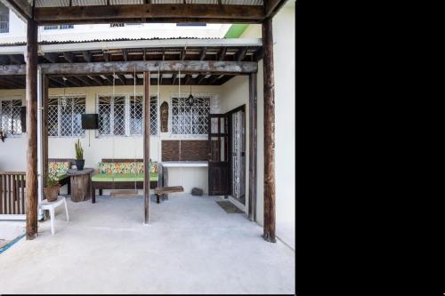 an open patio with a bench and a table at Breezy Castle Villa with private pool overlooking the Sea and Blue Mountains in Port Maria