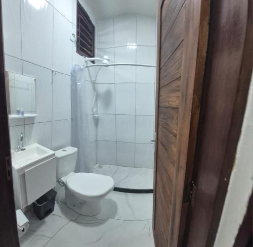 a bathroom with a toilet and a shower and a sink at Residencial Rosa da Barra in Canguaretama