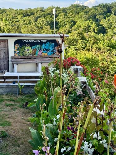 a bench in a garden with flowers at Breezy Castle Villa with private pool overlooking the Sea and Blue Mountains in Port Maria