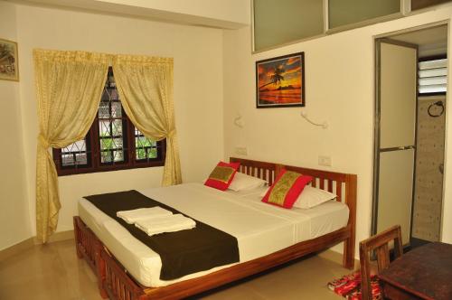 a bedroom with a bed and a window at Lazar Residency Homestay in Cochin