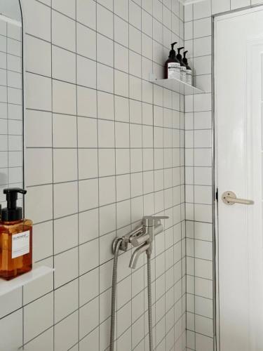 a bathroom with a shower with white tiles at Aralla Stay-고척돔 15분 거리 #홍대 이태원 영등포 여의도 대중교통 30분 내 도착 #목동역 도보 15분 #목동역 차로 5분 in Seoul