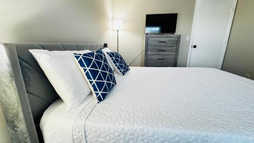a bedroom with a bed with a blue and white pillow at Cozy Escape, rooms in Charlotte in Charlotte