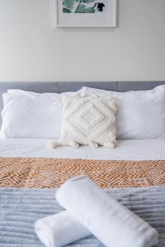 a bed with white sheets and pillows on it at Iconic CBD Gem - Stroll to QVB & Opera House in Sydney