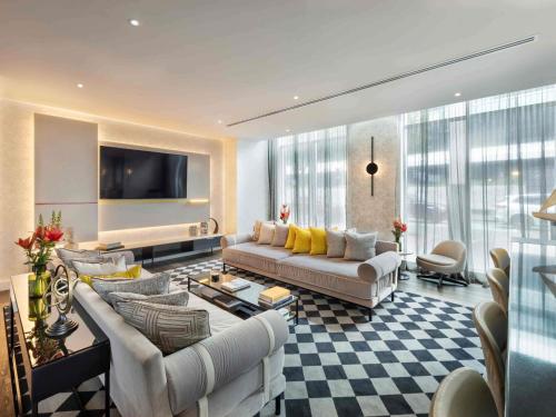 a living room with a couch and a tv at Sofitel Auckland Viaduct Harbour in Auckland