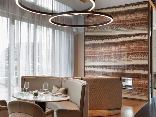a dining room with a table and a chandelier at Sofitel Auckland Viaduct Harbour in Auckland