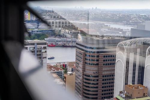 a view of a city with a river and buildings at Iconic CBD Gem - Stroll to QVB & Opera House in Sydney