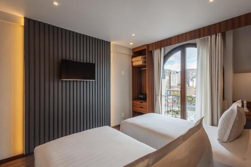 a hotel room with two beds and a window at DREAM By Stannum Hotel in La Paz
