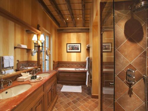 a bathroom with two sinks and a shower at Hotel de la Cité Carcassonne - MGallery Collection in Carcassonne