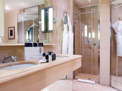 a bathroom with a sink and a shower at Hotel de la Cité Carcassonne - MGallery Collection in Carcassonne