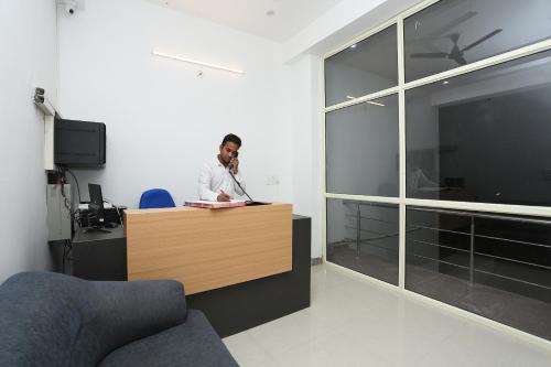 a man is sitting at a desk in an office at Hotel O R.K residency in Gurgaon