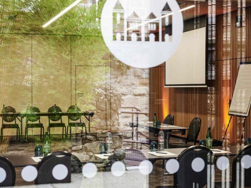 a conference room with tables and chairs and a screen at Hotel de la Cité Carcassonne - MGallery Collection in Carcassonne