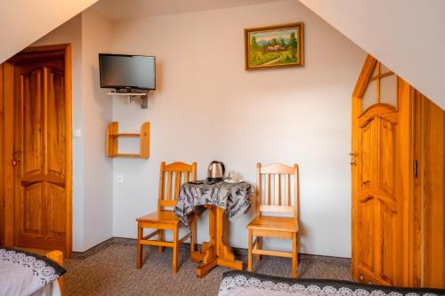 a room with a table and two chairs and a tv at Dom Wypoczynkowy Elżbieta in Poronin
