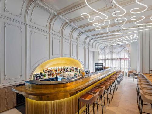 a bar in a restaurant with a lot of chairs at The Playford Adelaide - MGallery in Adelaide