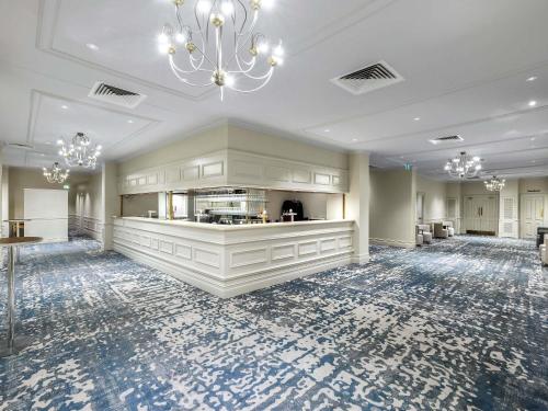a large room with a kitchen and a chandelier at The Playford Adelaide - MGallery in Adelaide