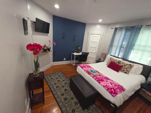 a bedroom with a bed and a vase of flowers at downtown and secluded in Manchester