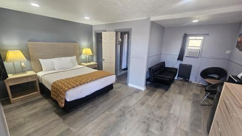a hotel room with a bed and a chair at Travelers Inn in Flagstaff