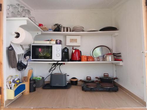 a kitchen with a microwave and a stove in a room at Casa dos Sonhos Glamping in Lagoa