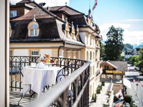 a table on the balcony of a building at Royal St. Georges Hotel Interlaken - MGallery Collection in Interlaken
