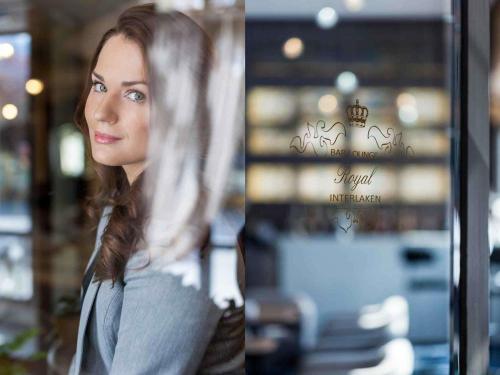 a woman standing in front of a window at Royal St. Georges Hotel Interlaken - MGallery Collection in Interlaken
