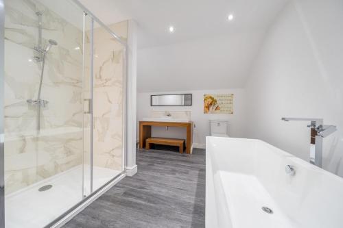 Un baño con ducha, bañera y lavabo. en Moor End Manor, en Poulton le Fylde