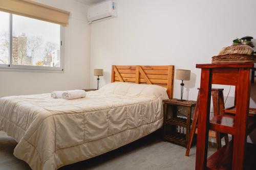 a bedroom with a bed and a table and a window at Asturiano 6 Miramar in Miramar