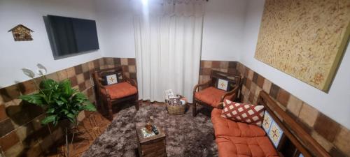 a living room with three couches and a television at Canto Mineiro in Tiradentes