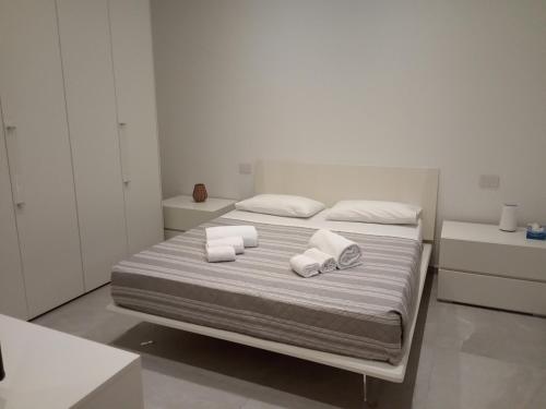 a white bedroom with a bed with towels on it at Residenza Milla in Alassio