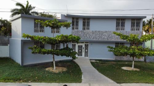 a white building with two trees in front of it at Casa Guadalupe in Campeche