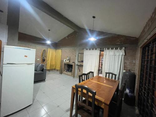 une cuisine avec une table et un réfrigérateur blanc dans l'établissement CASA EL GRINGO ubicada en Villa Parque Siquiman con vista al río tres habitaciones y capacidad para ocho personas, à Villa Parque Siquiman